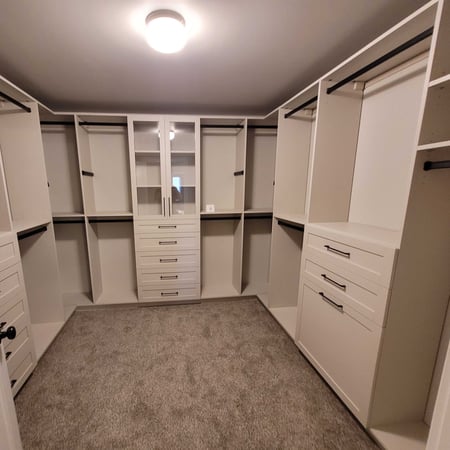 Custom Walk in Closet with doors and drawers and a light