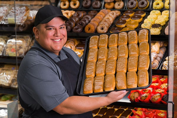 Man holding tray full of donuts