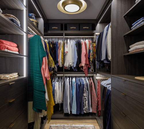 brown walkin custom closet with hanging shelving LED lighting and drawers