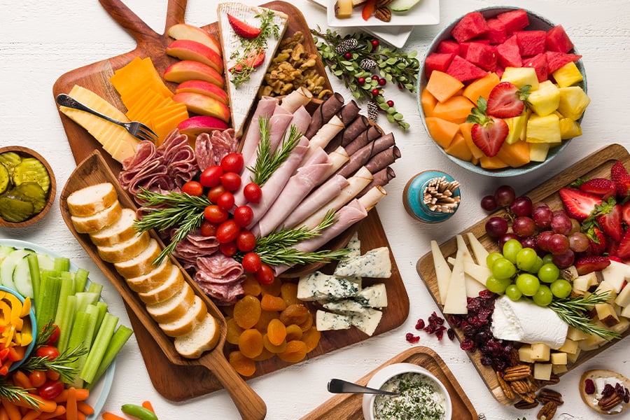 Meats cheeses fruits and vegetables on a table fresh from the store