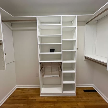 Virginia Beach - Custom closets - Custom walk-in closet with shelving tower and hanging rods on wood flooring.