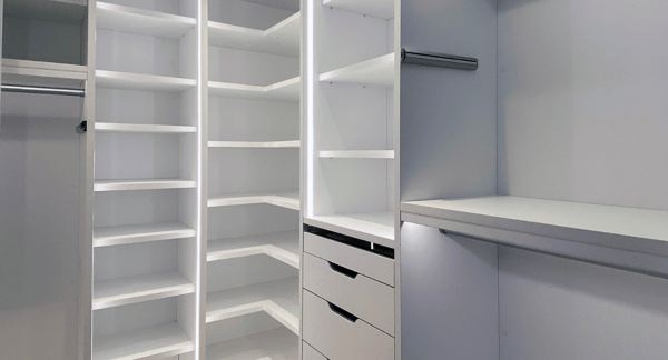 white walk-in closet with LED lighting, shelving, hanging and modern drawers with modern hardware Tribeca New York