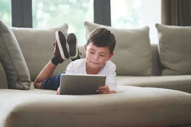 Niño con una tablet utilizando los servicios de Internet residencial