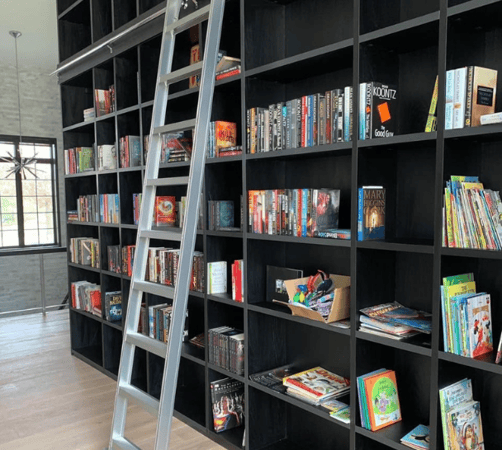 Custom wall book shelving with a sliding ladder.
