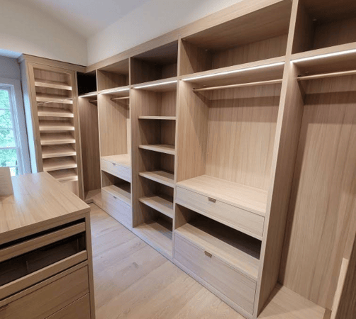 California Closets Hudson Valley NY Full Room Walk-in Closet in Natural Wood with Variety of Hanging Levels, LED Lighting, Angled Shoe Shelving and Center Island