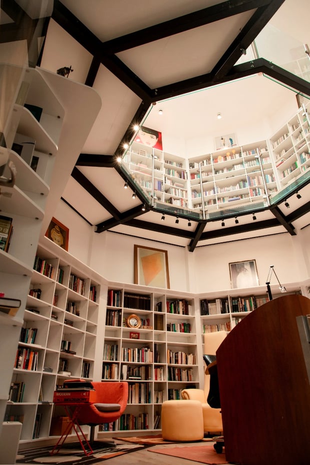 Custom built bookshelves lining the walls of a octagonal two story room