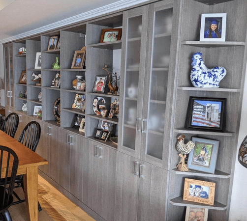 Img 6 California Closets Westchester New York Gray Book Shelves Living Room Wall Unit with Open and Closed Storage to showcase family photos, trophies, and figurines