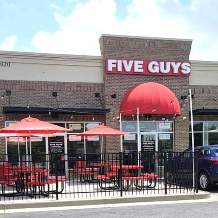 Exterior photograph of the entrance to the Five Guys restaurant at 3620 Camp Creek Parkway in Atlanta, Georgia.