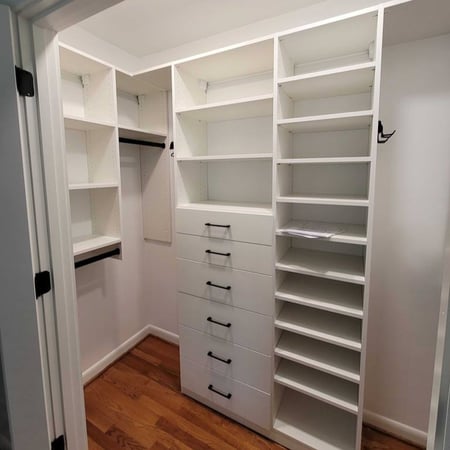 A custom white closet designed with shoe shelves and drawers.