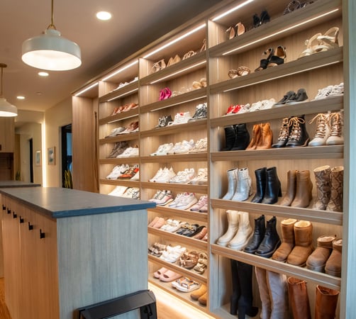 Shoe storage display with slanted shelves and custom lighting by California Closets, Tennessee.
