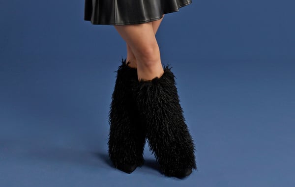 Woman is wearing black fur boots