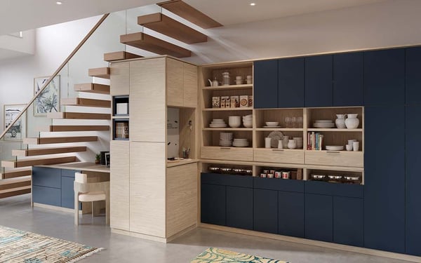 Custom under-stairs storage with workspace, pantry, and family command center in wood and navy finishes.