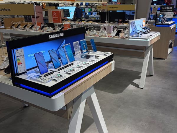 Vue du rayon téléphonie avec les produits disposés en magasin.