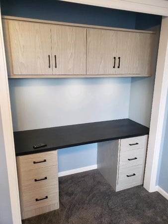 Natural wood grain desk with lighting and black countertop