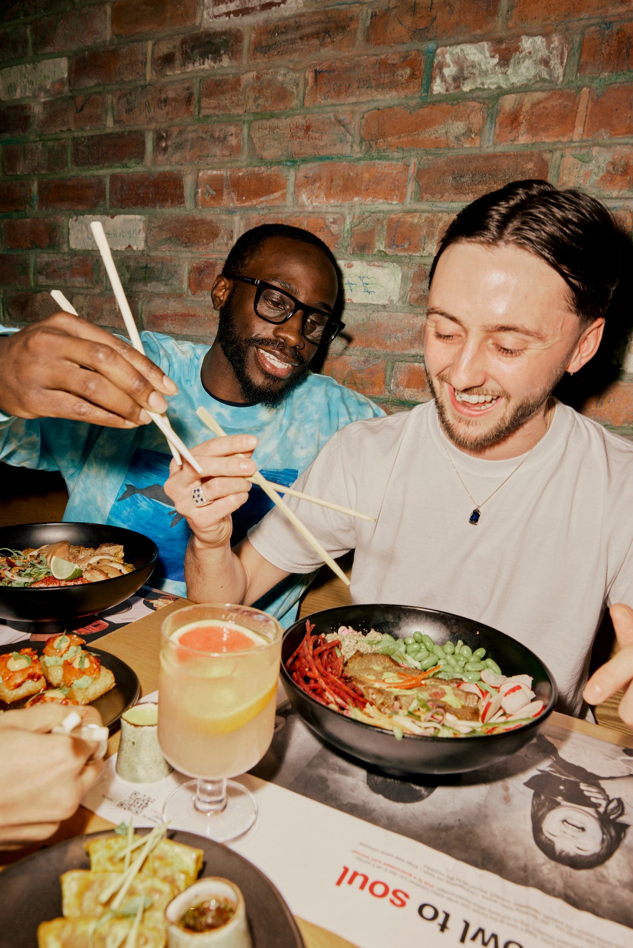 two men eating ramen noodles at wagamama