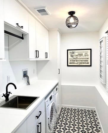 White laundry room with black hardware. Add a counter top and hanging bar for folding and hanging clothes while doing laundry.