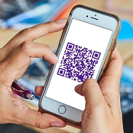 A cell phone with an image of a QR code