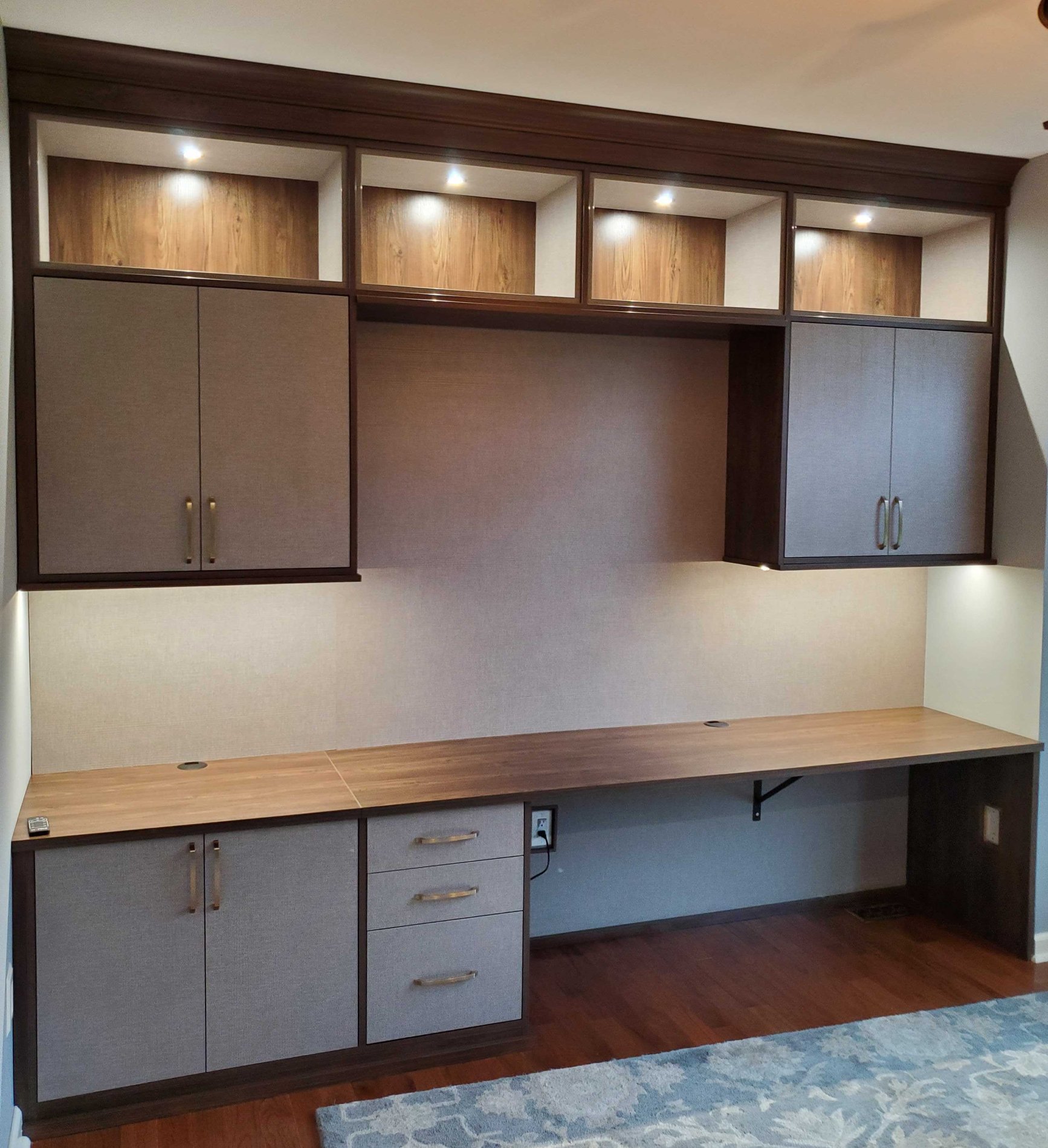 home office desk, cabinets and drawers with lighting in complementing finishes