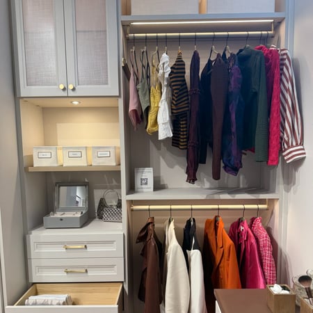 Walk in closet with lighting and drawers for extra storage.