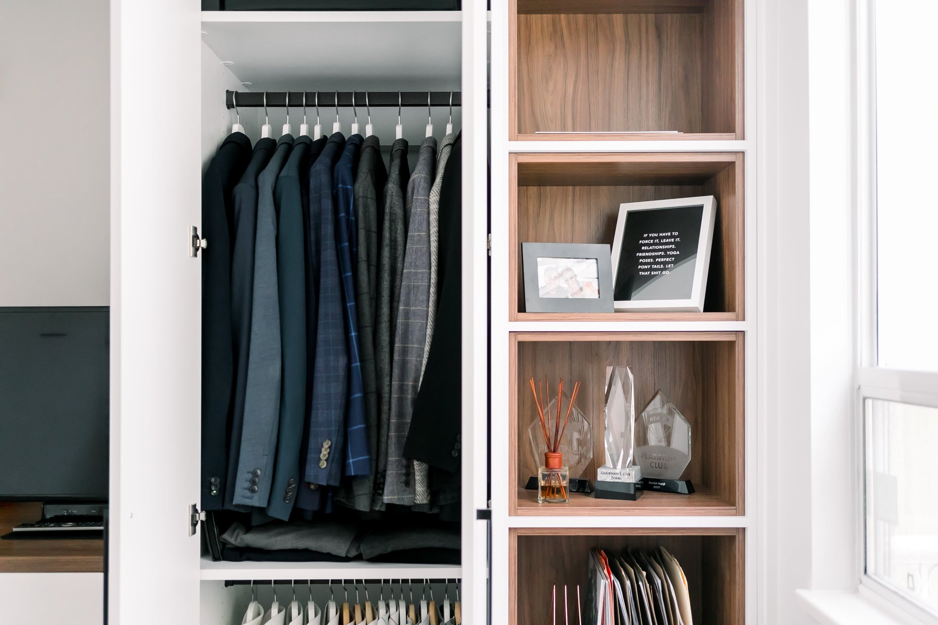 Open cubby storage beside a cabinet with hanging space inside