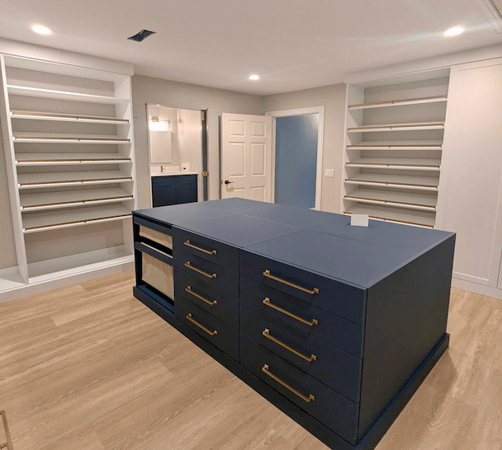 luxe white walk-in closet with blue center island