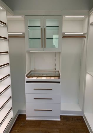 Luxe white walk-in closet with gold accents