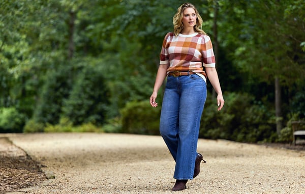 Woman is wearing plus size wide leg blue jeans.