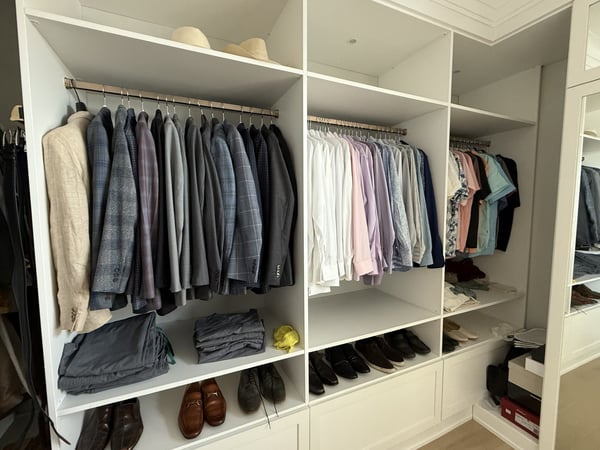 Men's walk in closet with space for suite jackets and shoes.