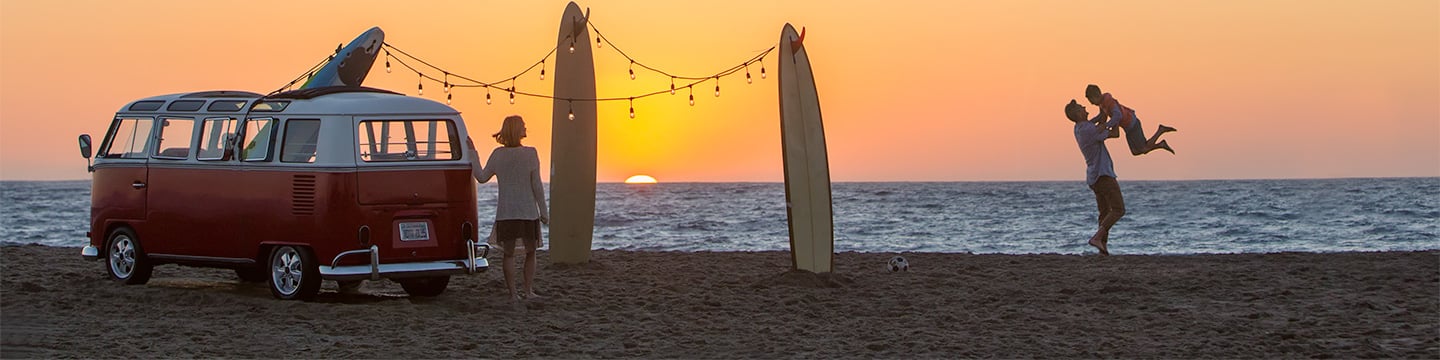 Family with surfboards at a beach with sunset