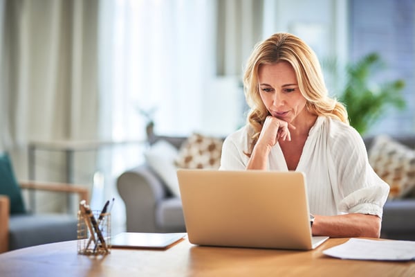 Woman sitting at table looking at computer