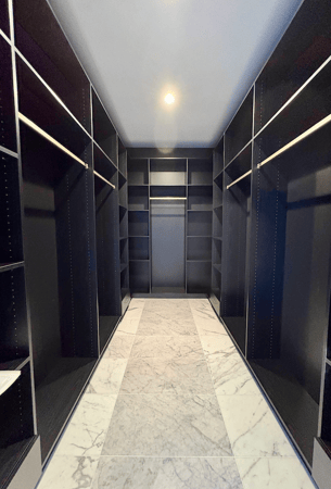 black custom walk in closet with hanging rods and shelves in Bloomfield Hills, MI.