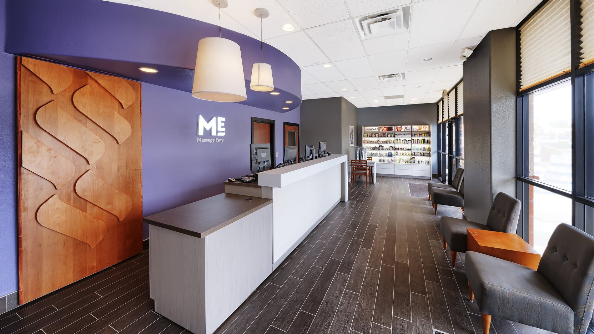 Inside a Massage Envy location with Purple walls and exposed wood and plus ...