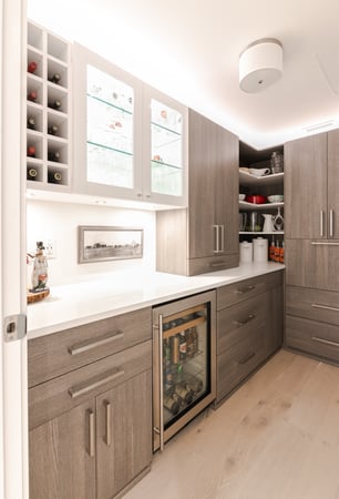 Modern pantry with neutral wood tones and a glass display cabinet