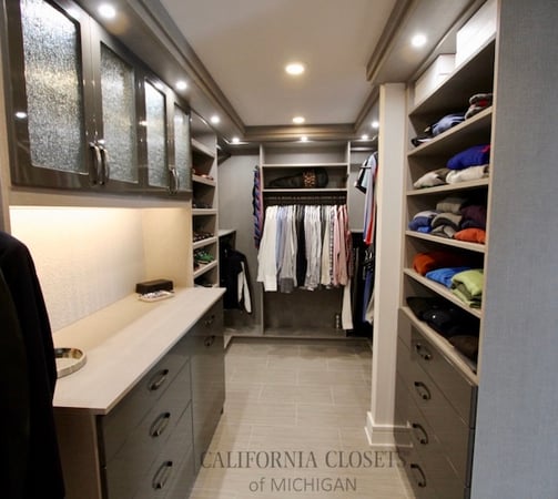 Walk-in for him with puck lighting and grey acrylic drawers.