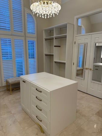 Custom walk in closet with an island.