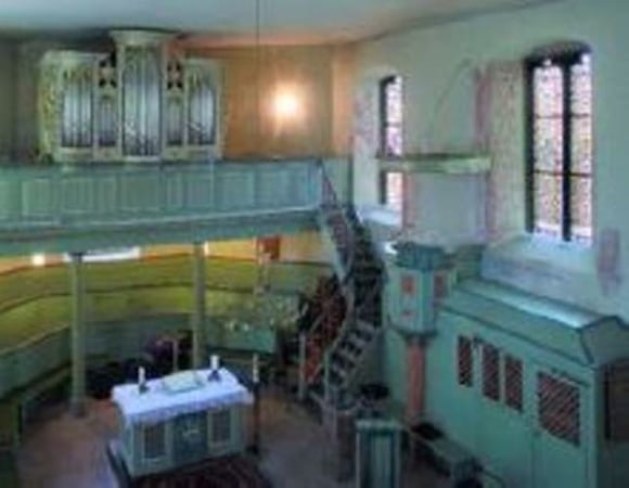 Zu sehen ist das Innere der Kirche Nieder-Hilbersheim. Es ziehen sich mehrere Ebenen durch das Gebäude, wodurch eine gewisse Tiefe entsteht.