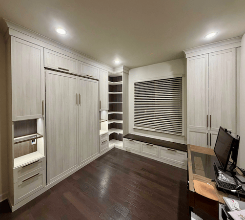 Wall bed with light wood, shelving, drawers, and a desk