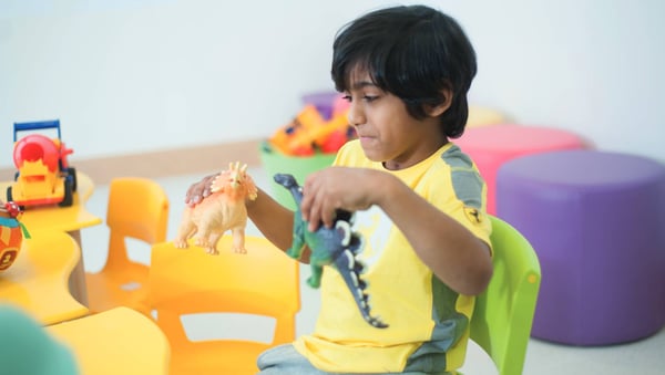 Child playing with dinosaurs in the hospital play room
