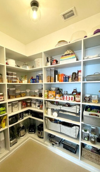 pantry shelves filled with food and appliances in white