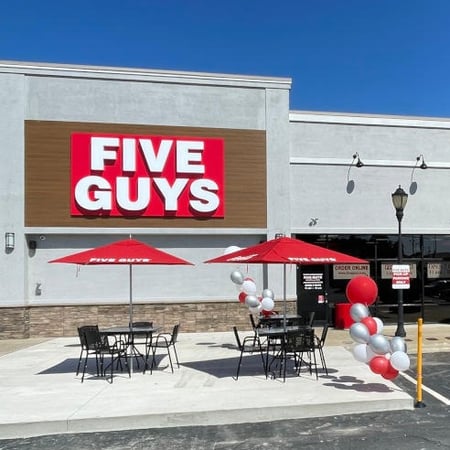 Exterior photograph of the entrance to the Five Guys restaurant at 309 Huffman Mill Road in Burlington, North Carolina.