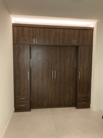 Custom guest room storage with Sorrento finish, matte aluminum hardware, and uplighting.