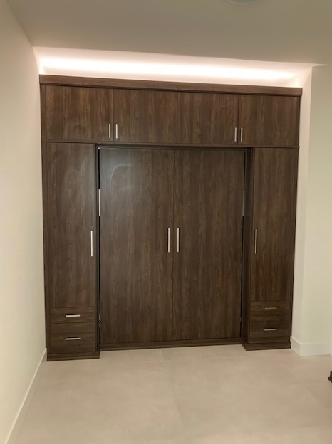 Custom guest room storage with Sorrento finish, matte aluminum hardware, and uplighting.