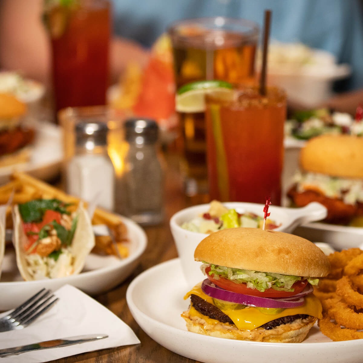 Table full of Original Joe's comfort food, Caesar Cocktails and cold beers.