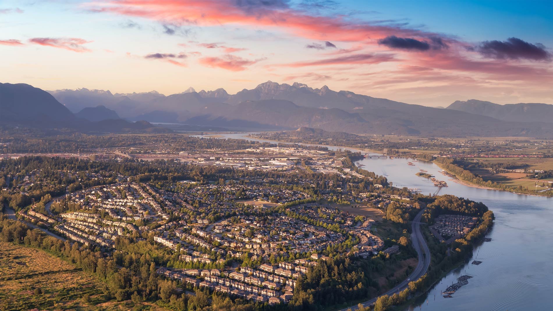 Aerial view of Coquitlam with mountain range in background.