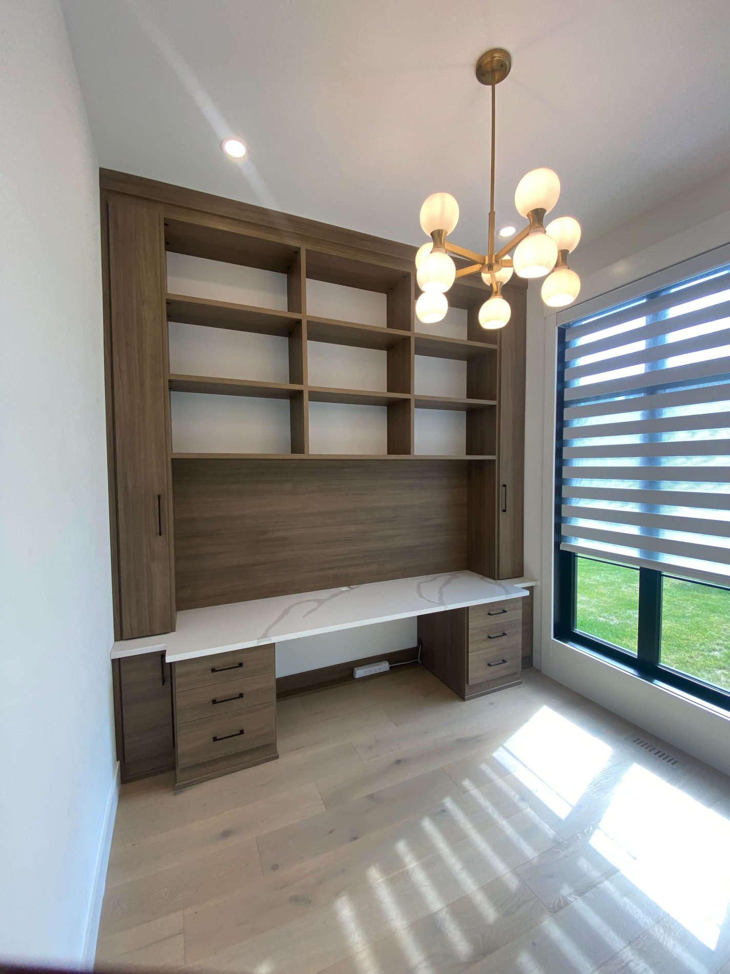 California Closets home office in a mid-tone wood grain finish and a contrasting white countertop.