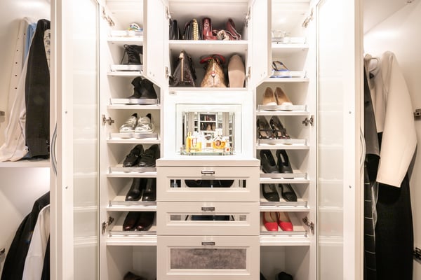 Pull out shelving for shoe storage in a white walk in closet
