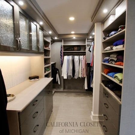 Walk-in for him with puck lighting and grey acrylic drawers.