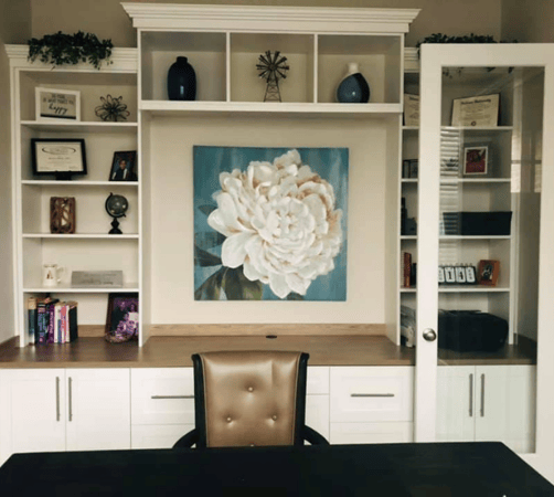 Home office space with custom shelving, drawers, and cabinets.