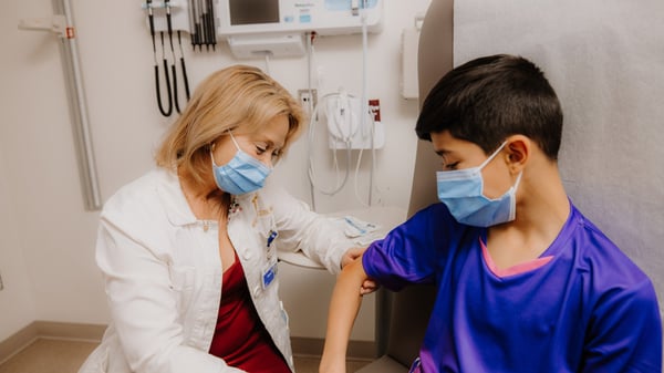Doctor examining young patient's arm