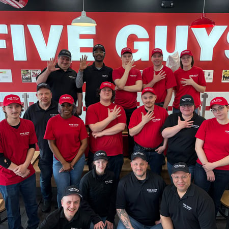 Crew members pose for a photograph inside the dining room ahead of the reopening of the Five Guys restaurant in Hamburg, New York.